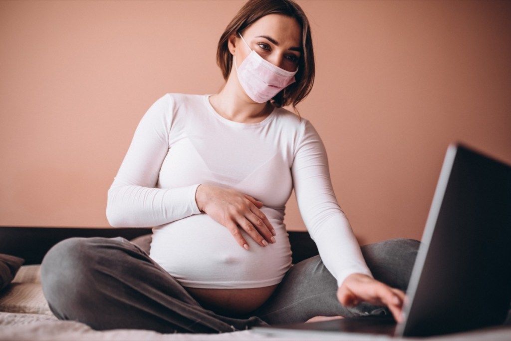 Phụ nữ có thai đeo mặt nạ, sử dụng máy tính