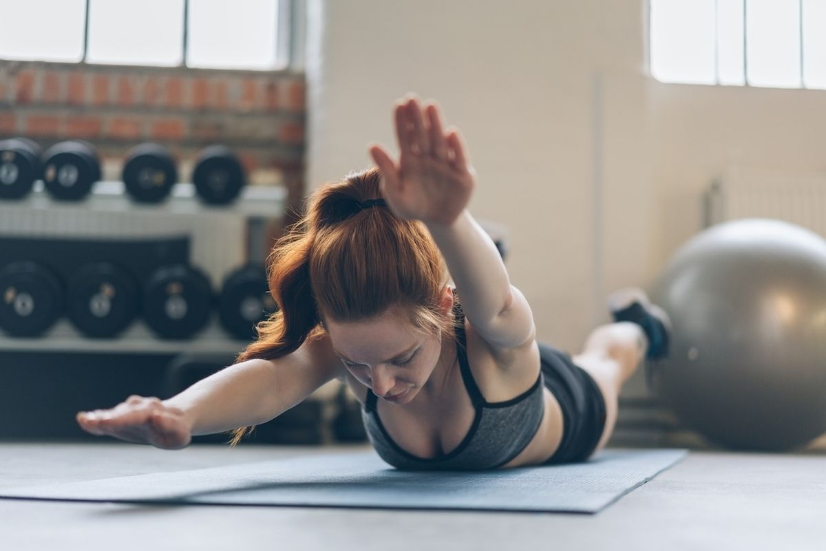 Mladá žena, tónování břišních svalů, cvičit na podložce v tělocvičně
