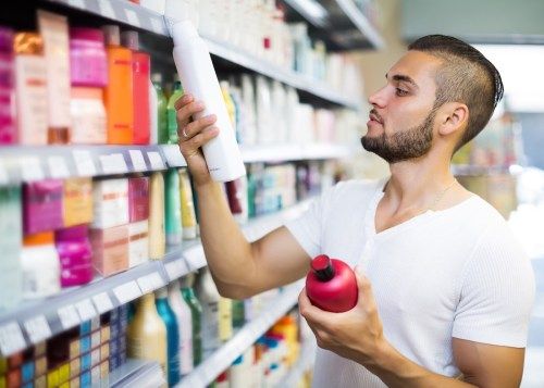 Attraktiv mann som kjøper sjampo i kjøpesenter - Image
