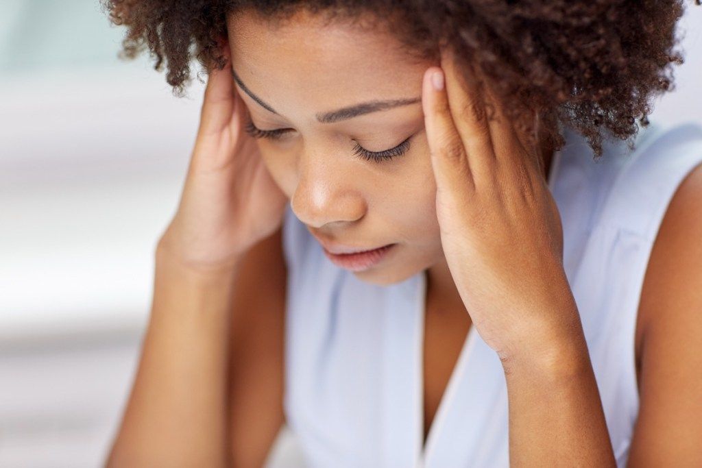 хора, емоции, стрес и концепция за здравни грижи - нещастна афроамериканска млада жена, която докосва главата си и страда от главоболие симптоми на рак