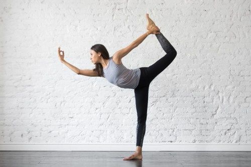 Mujer realizando pose de bailarina de yoga