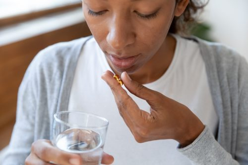   Žena prehĺta pilulku