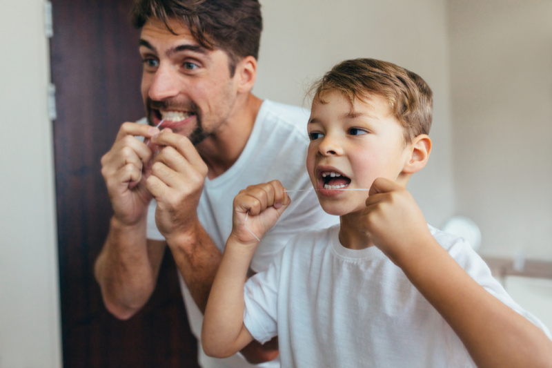   tată și fiu folosesc ața dentară, cum s-a schimbat educația