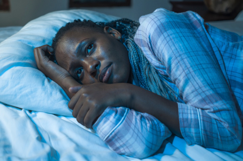   mujer acostada en la cama en casa infeliz e insomne ​​por la noche sintiéndose abrumada sufriendo problemas de depresión e insomnio