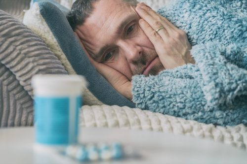   Muž v posteli vedľa antidepresív