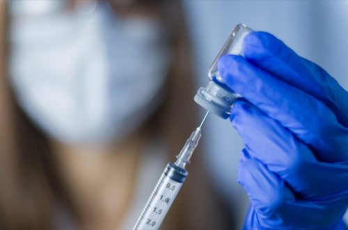   vacuna en manos de los investigadores, la doctora sostiene una jeringa y un frasco con la vacuna para la cura del coronavirus. Concepto de tratamiento, inyección, inyección y ensayo clínico del virus de la corona durante la pandemia.