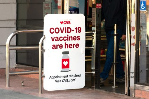   Знакът Covid-19 vaccines are here рекламира място за ваксиниране срещу коронавирус в аптечния магазин CVS. - Пало Алто, Калифорния, САЩ - февруари 2021 г