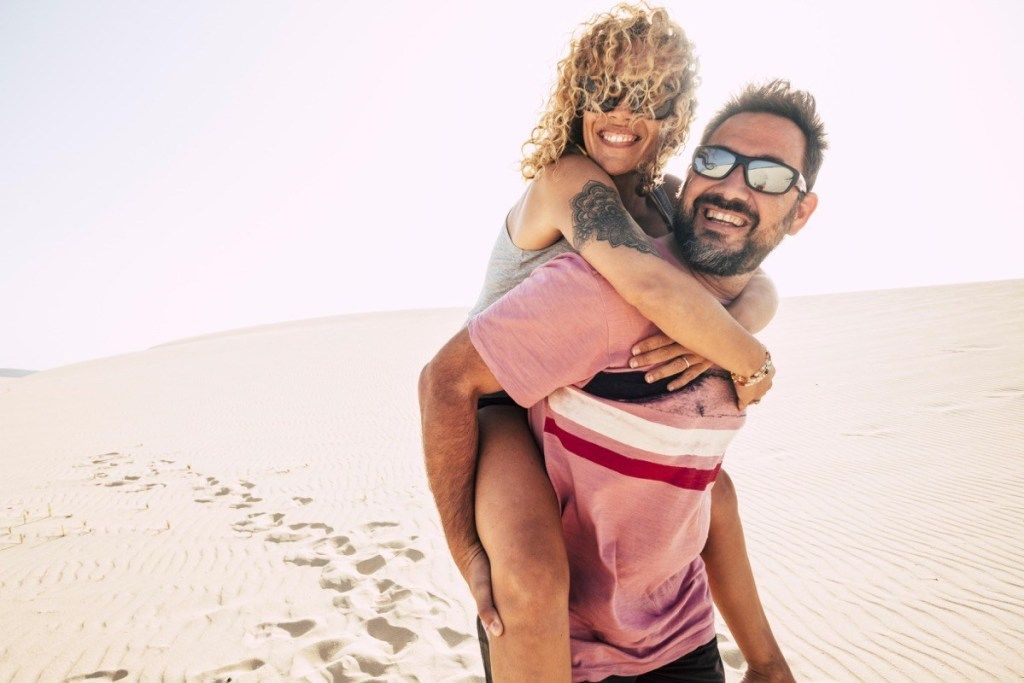 Glückliches Paar über 40 in der Wüste amüsiert sich auf Abenteuer