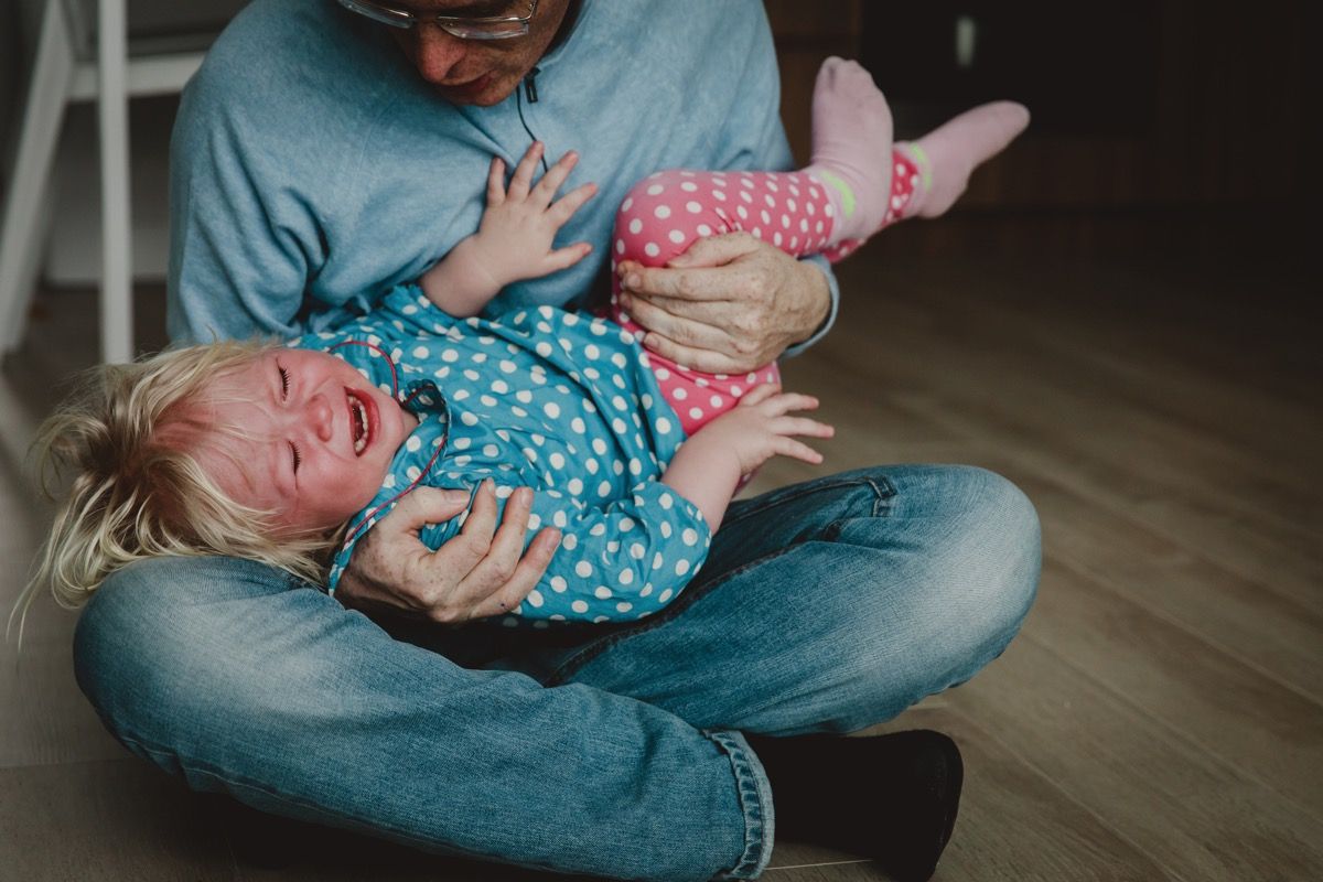 sunku auklėti - tėtis bando paguosti šaukiantis verkiantis vaikas, pavargęs ir išsekęs tėvas