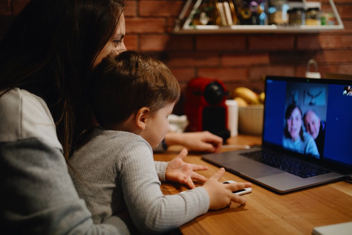 Abuelos en cuarentena en casa con videollamada con nieto e hija