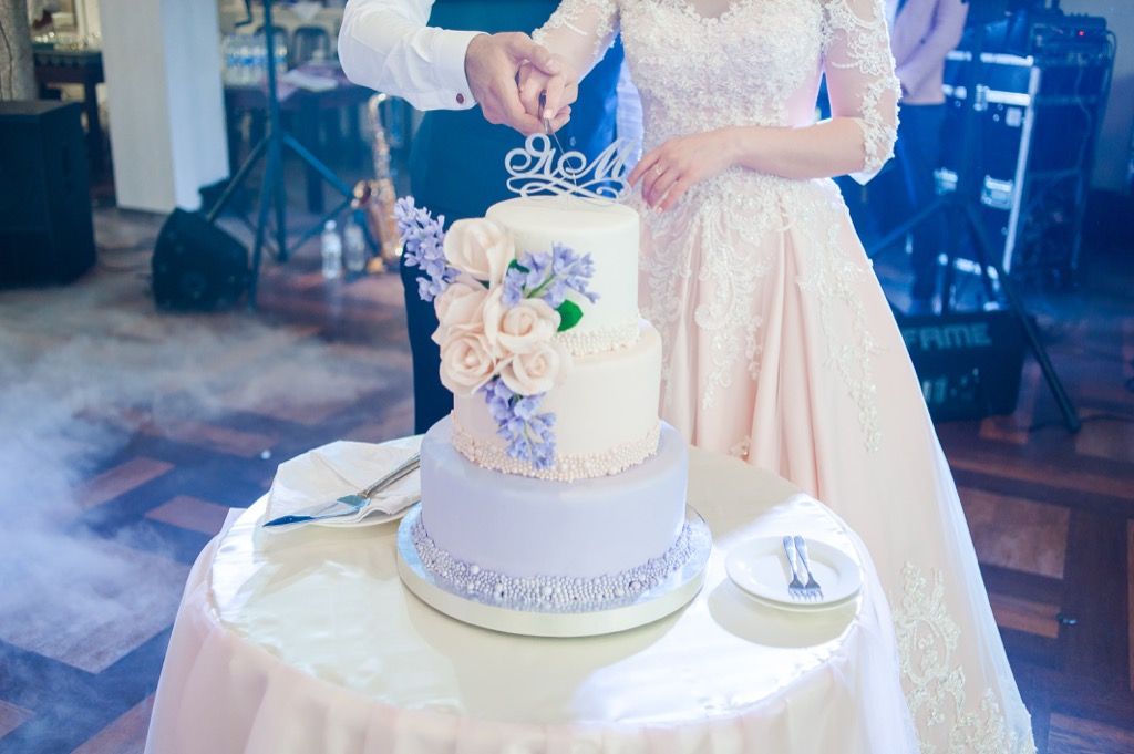La novia y el novio cortan el pastel de bodas. Esta es la edad a la que la mayoría de las personas se casan en todos los estados de EE. UU.