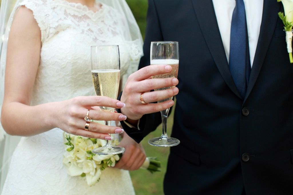 Pareja de novios sosteniendo champán Esta es la edad a la que la mayoría de las personas se casan en todos los estados de EE. UU.