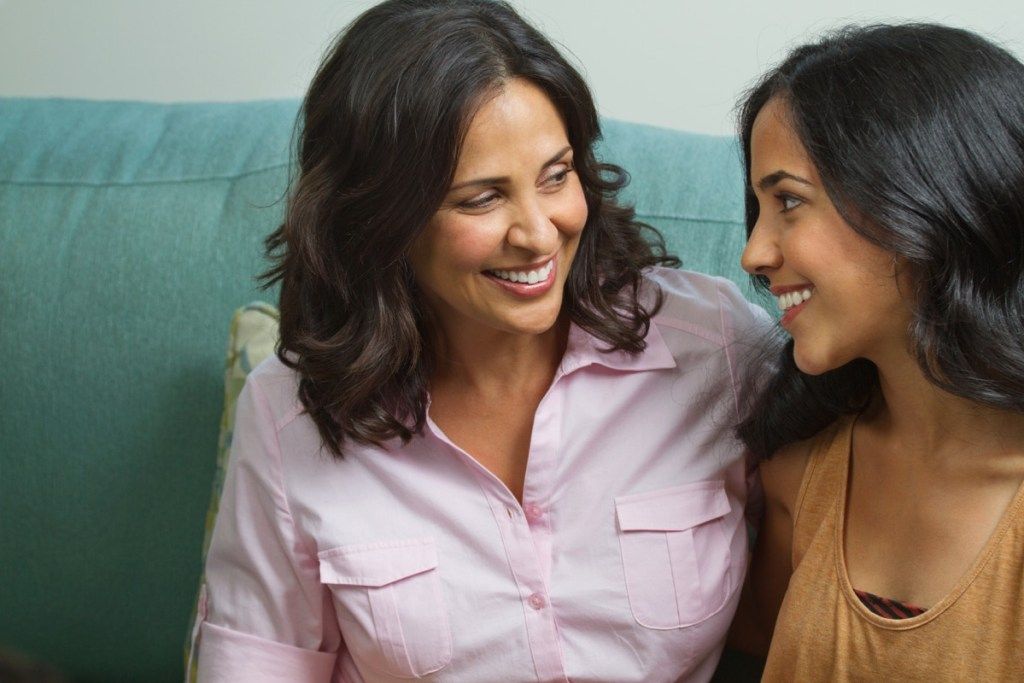 mãe hispânica e filha adolescente conversando