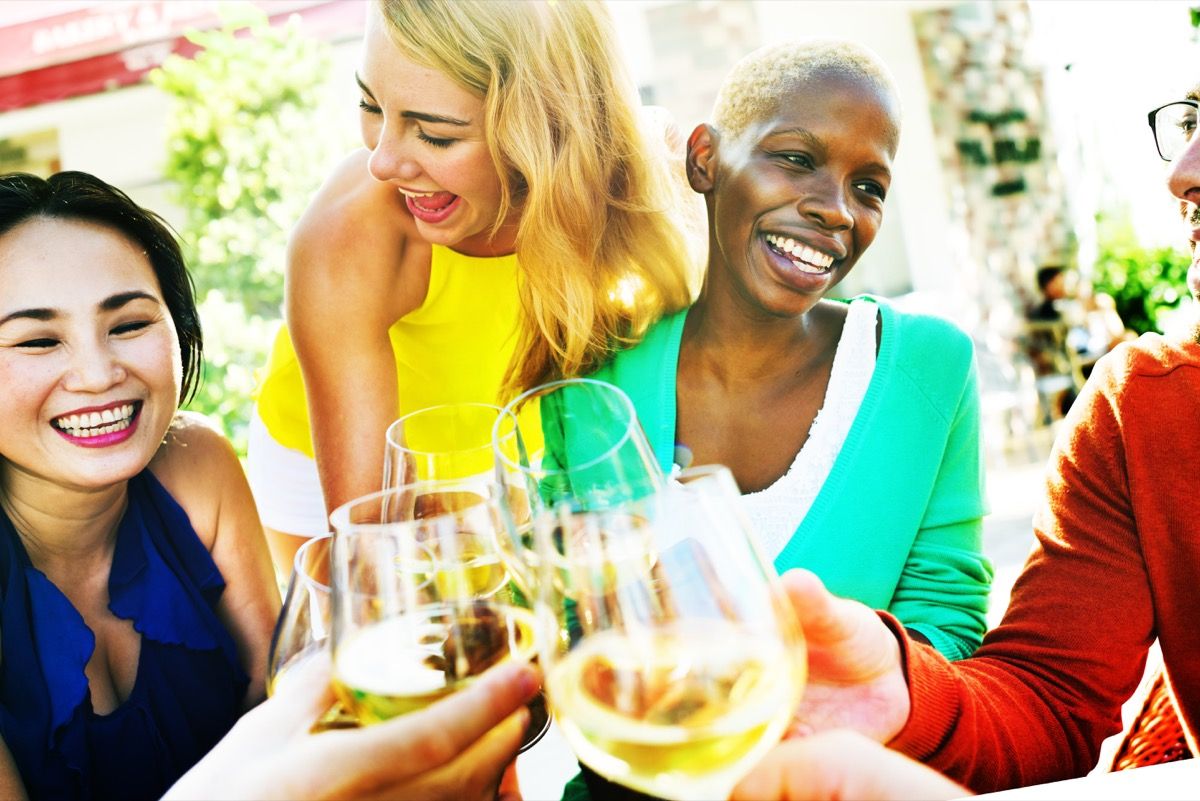 Eldre kvinnelige venner som henger og drikker litt vin