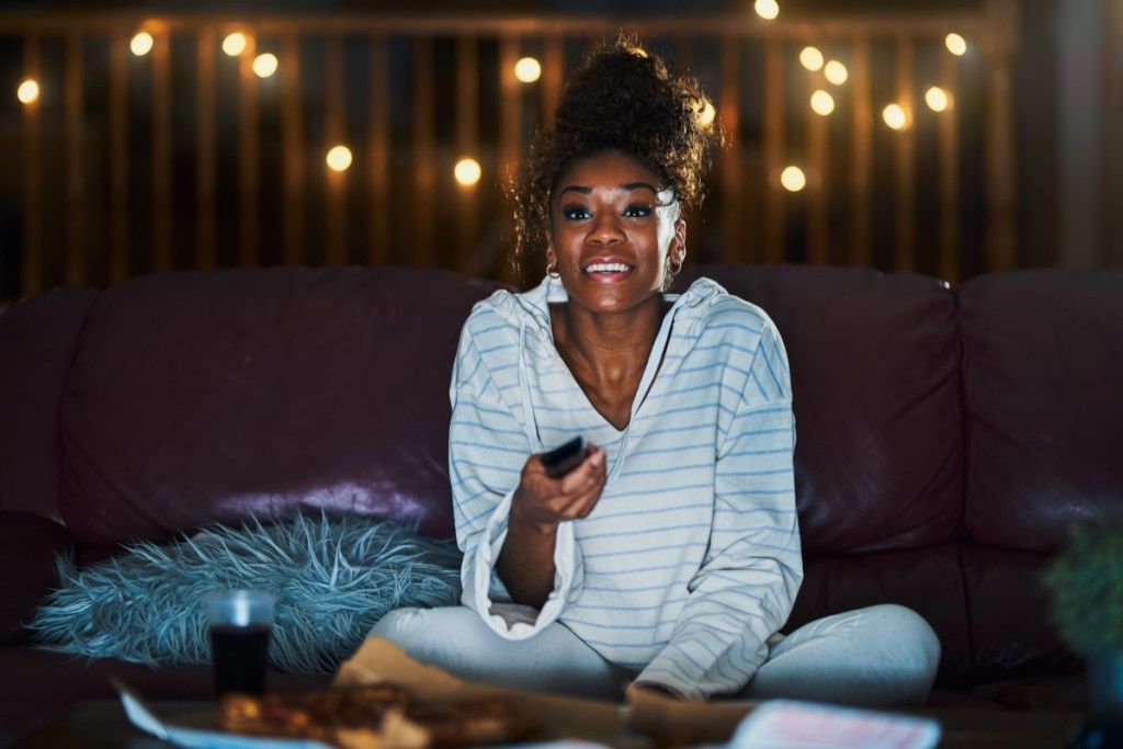 Kvinna som håller sig uppe sent och tittar på TV, förhållandevitt lögner