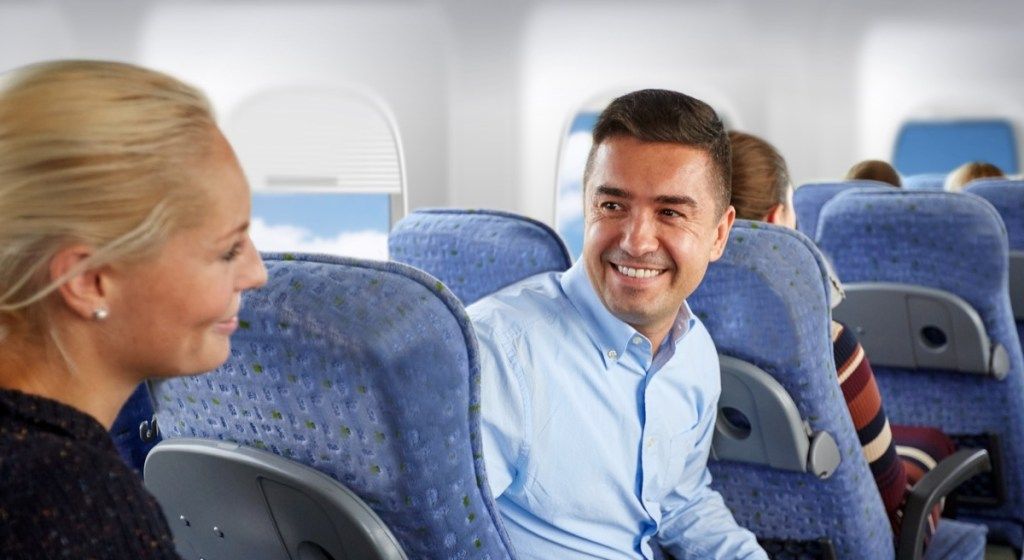 Kaksi ihmistä flirttailee lentokoneella