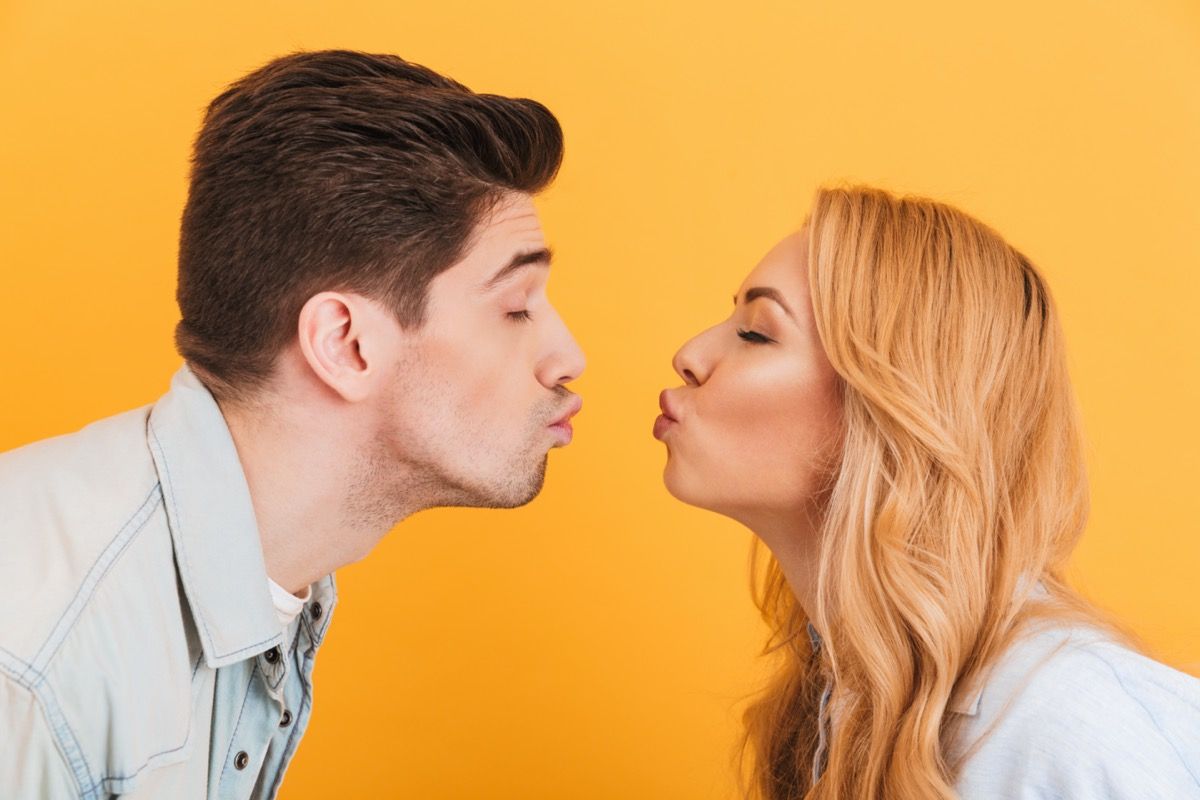 Ung mann og kvinne i ferd med å kysse