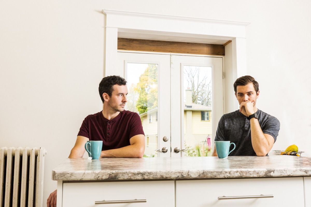 homopari kokee suhdeongelmia kotona istuessaan keittiön saarella