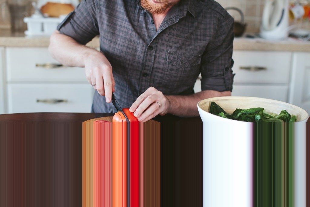 mies leikkaa tomaatteja keittiössä, mitä hän haluaa sinun sanovan