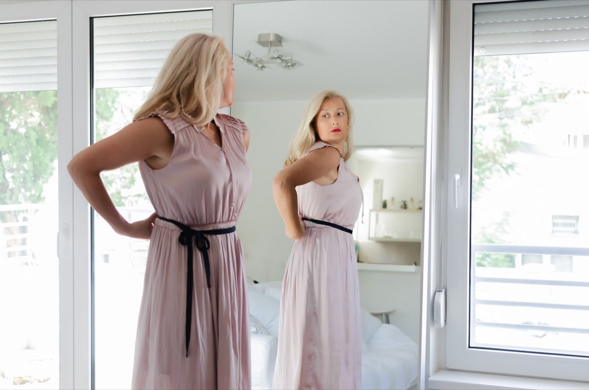 Moteris žiūri į save veidrodyje
