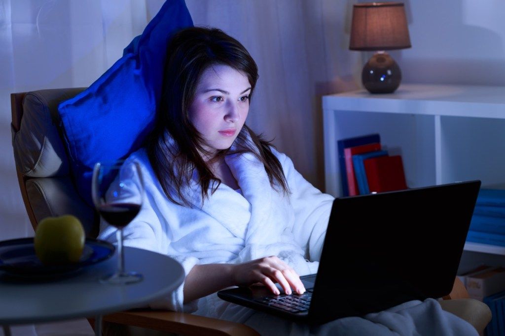 Žena na svém počítači v noci, tajný e-mail