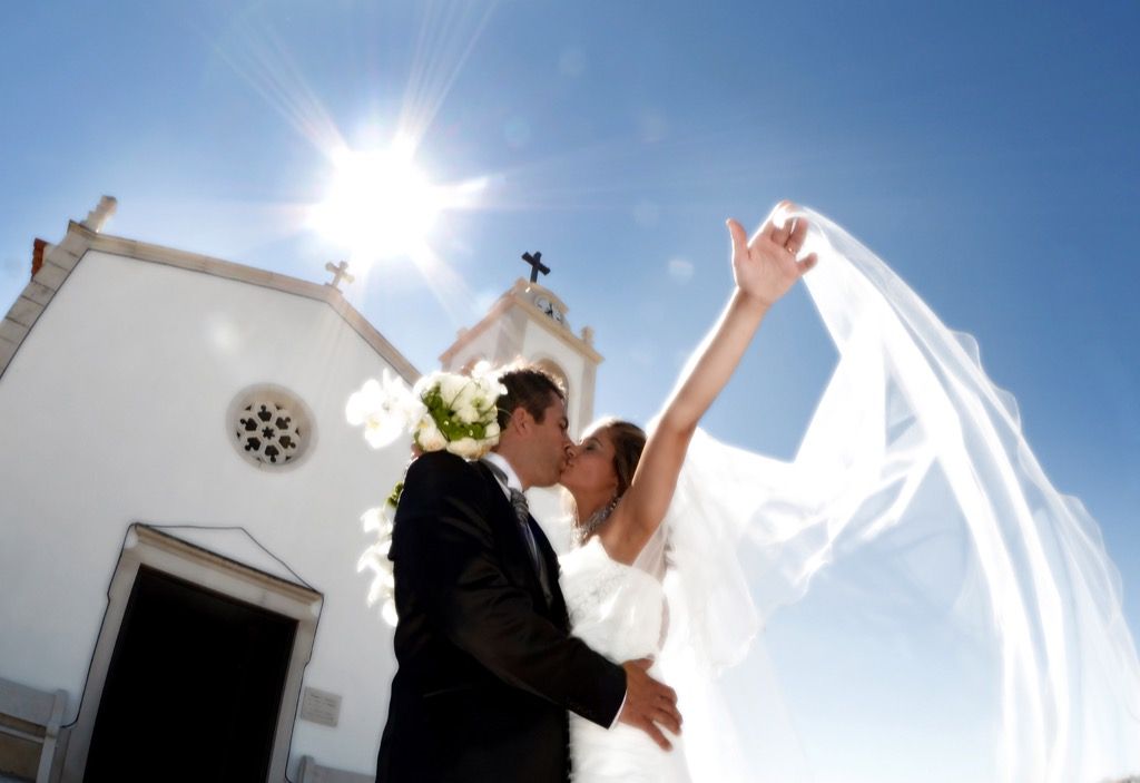 pareja besándose fuera de la iglesia 20 tradiciones de bodas anticuadas que ya nadie hace