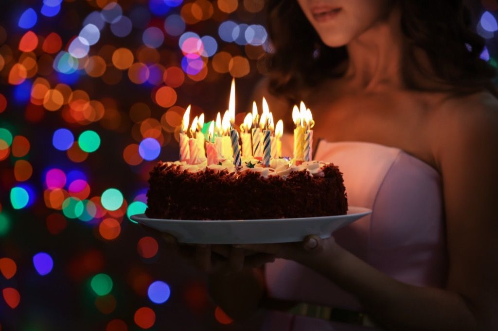 سالگرہ کی تقریب میں عورت کیک پکڑے ہوئے کمٹ