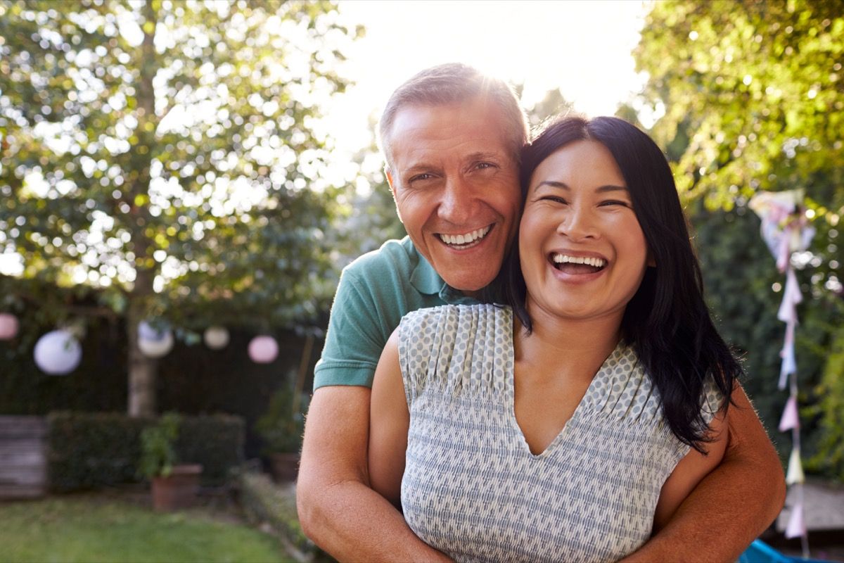 laiminga vidutinio amžiaus azijietė ir baltasis vyras lauke
