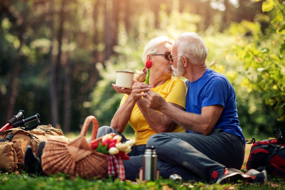 Älteres Paar, das auf Picknick küsst