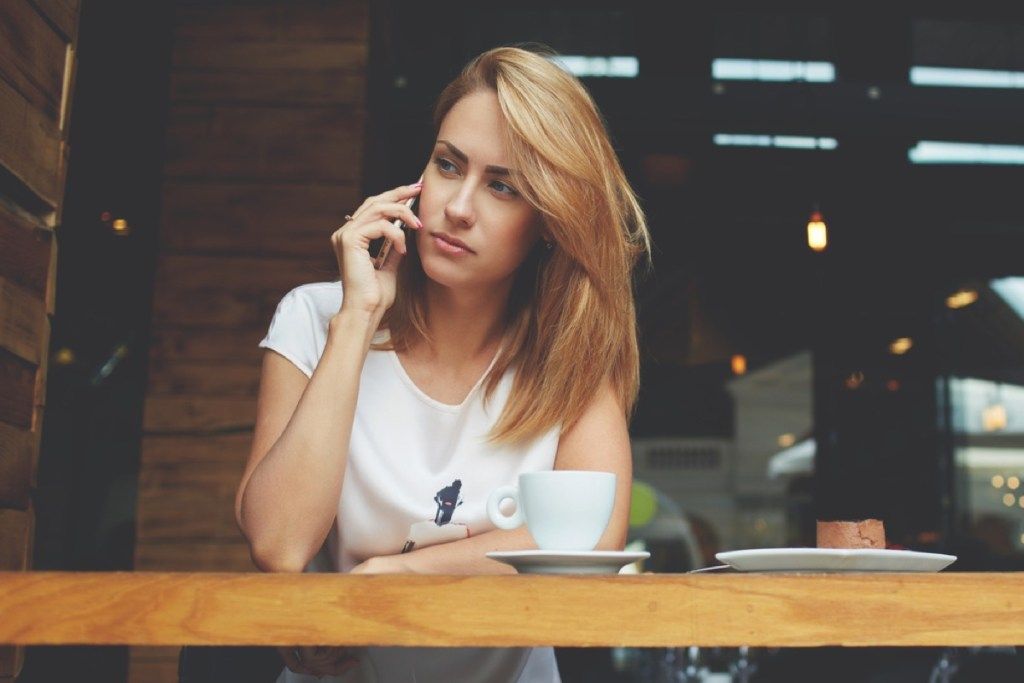 người phụ nữ căng thẳng khi nghe điện thoại, những điều bạn không bao giờ nên nói với vợ / chồng của mình