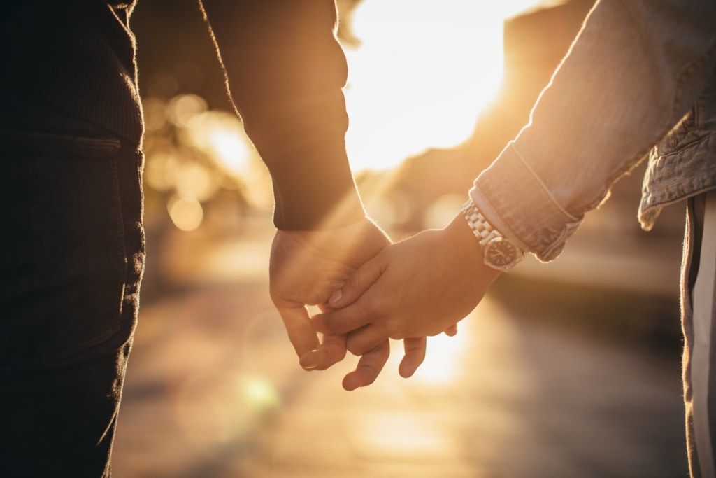 Moški in ženska, ki se držijo za roke