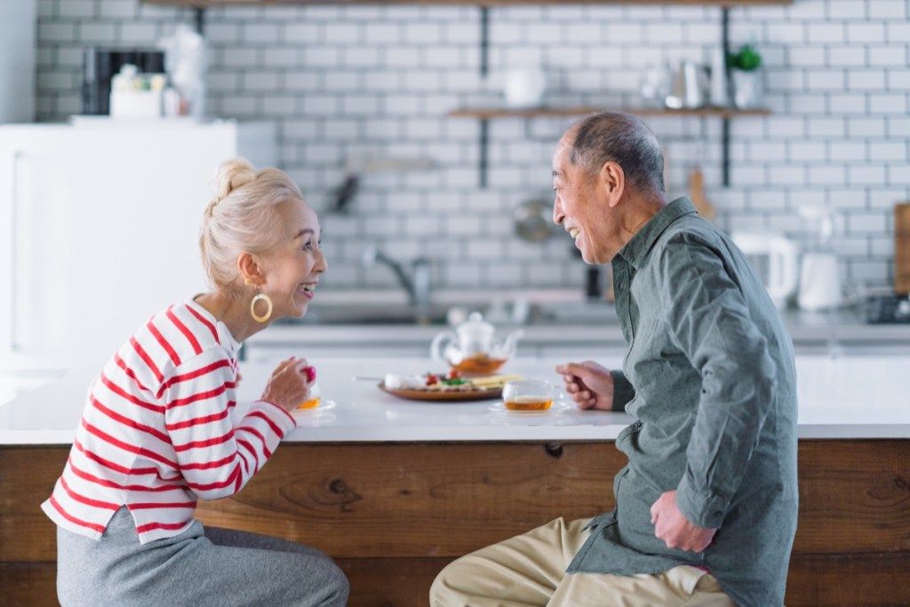 starejši par, ki v svoji kuhinji vzpostavi očesni stik