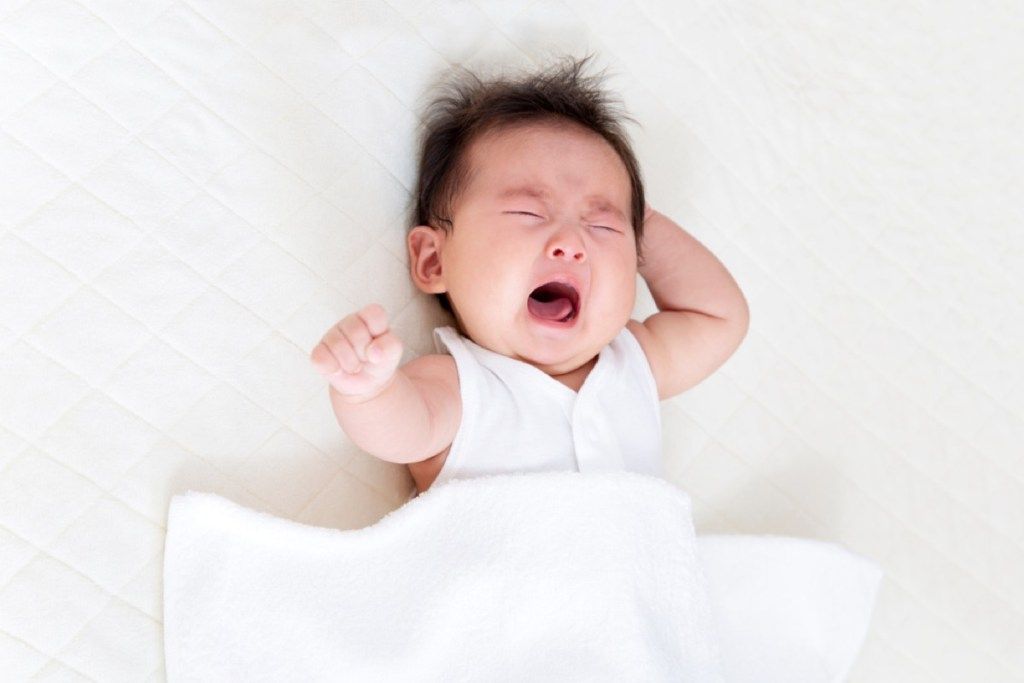 ทารกแรกเกิดร้องไห้อยู่บนเตียงคำแนะนำในการเลี้ยงดูที่ไม่ดี