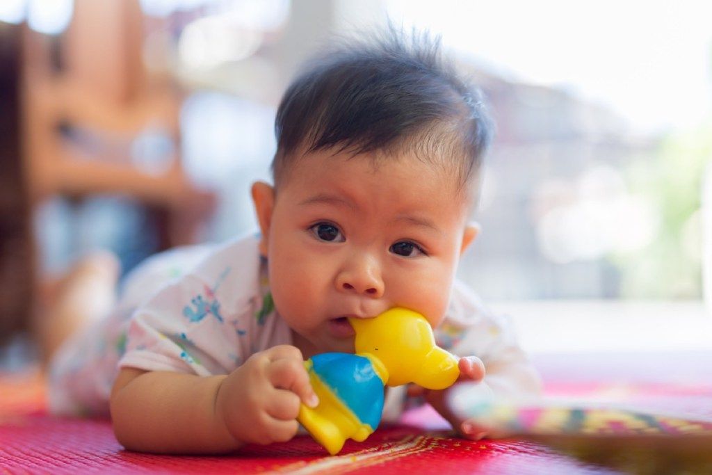 baby kauwt op speelgoed, slecht ouderschapsadvies