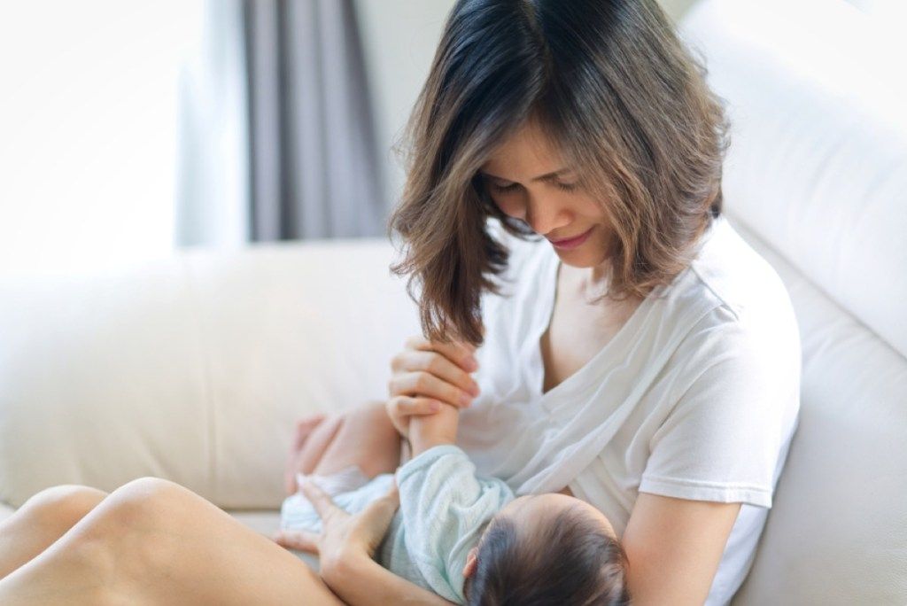 アジアの女性の母乳育児の赤ちゃん、悪い子育てのアドバイス