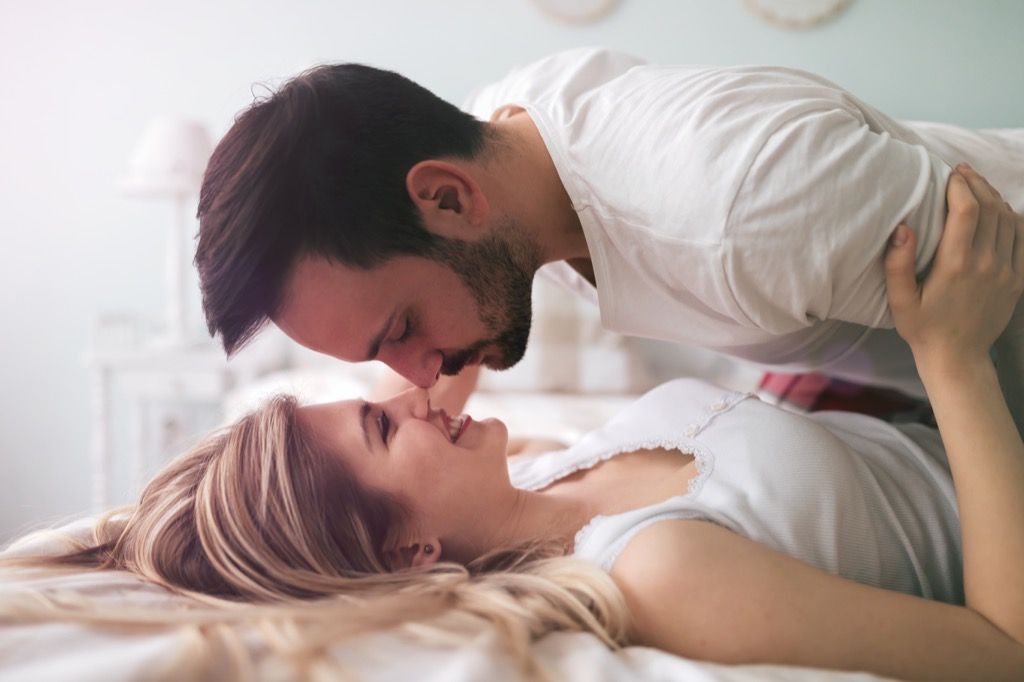 जोड़े को बिस्तर पर चुंबन, संकेत अपने पति को धोखा दे रही है