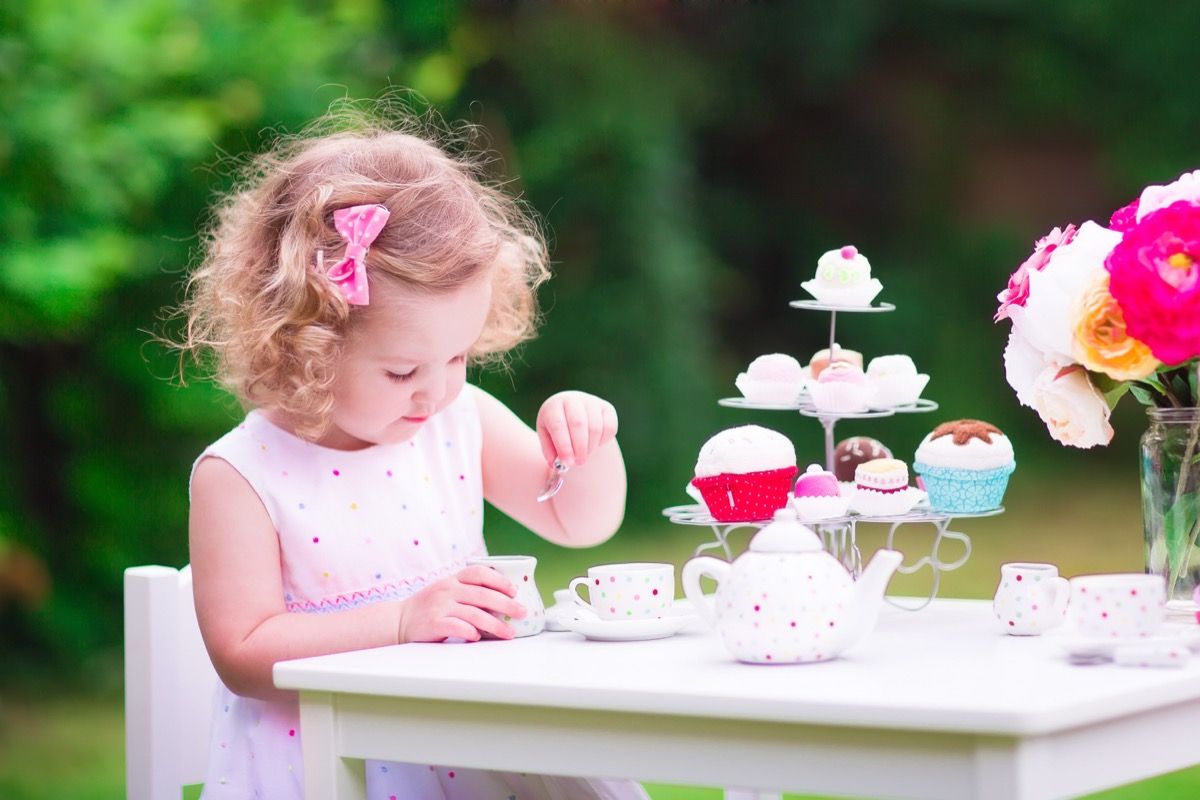 ילדה קטנה עורכת מסיבת תה בחוץ