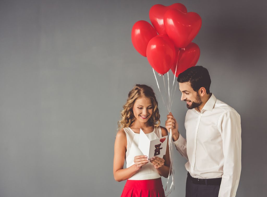 Muškarac iznenađujući ženu s balonima Romantika