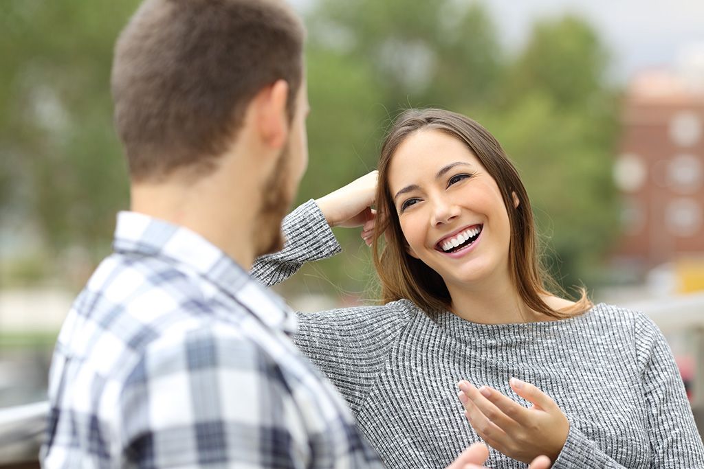 vīrietis un sieviete smejas ārpus datuma, sierīgi uzņem rindas