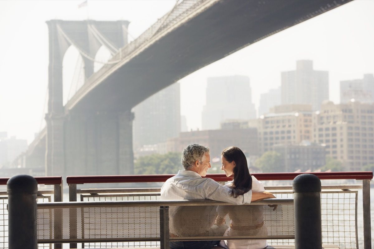 Köprüde bir bankta oturan Çift
