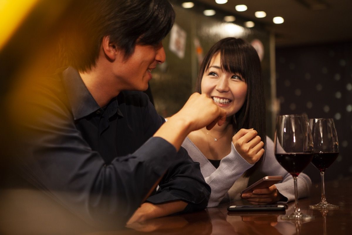to personer på en første date som snakker over et glass vin