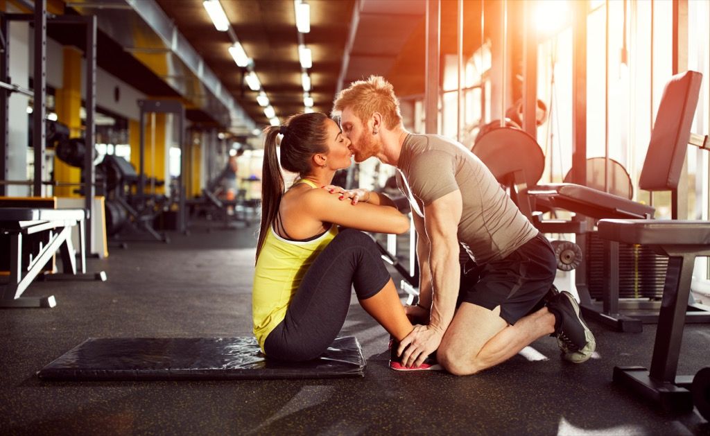 pareja besándose y haciendo ejercicio en el gimnasio