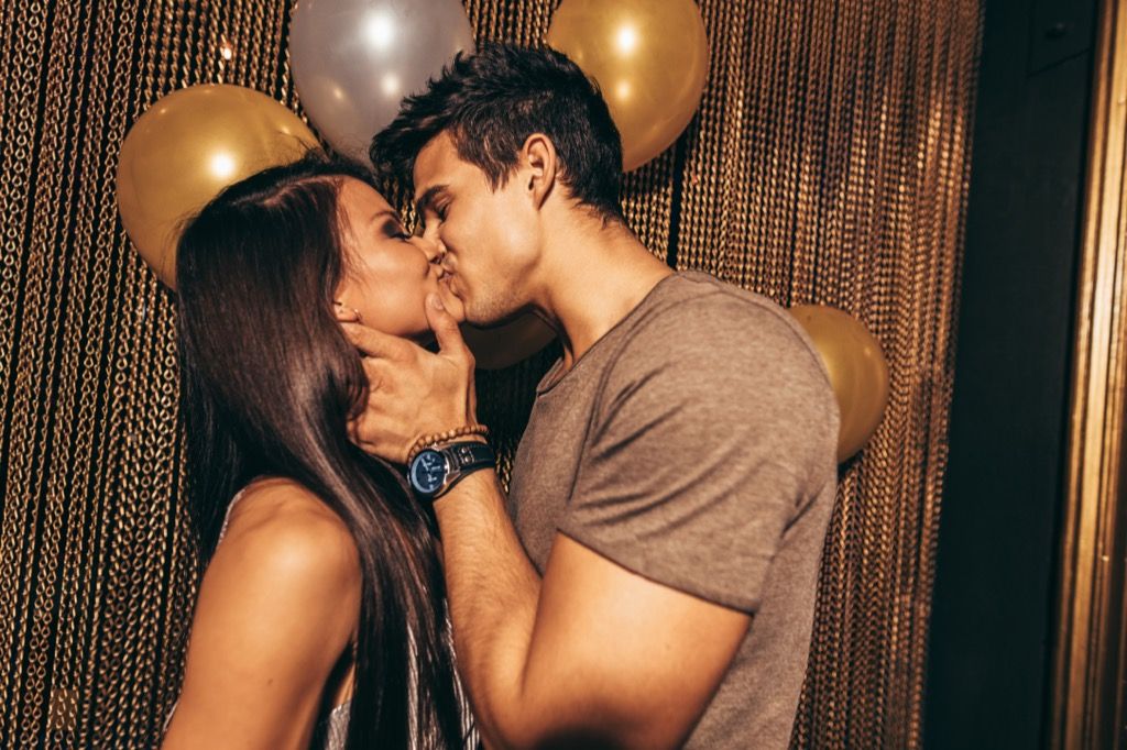 pareja besándose frente a globos