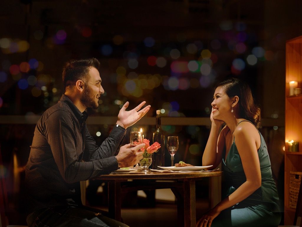 vīrietis un sieviete randiņu restorānā sveču gaismā, kā uzzināt, vai meitene jums patīk
