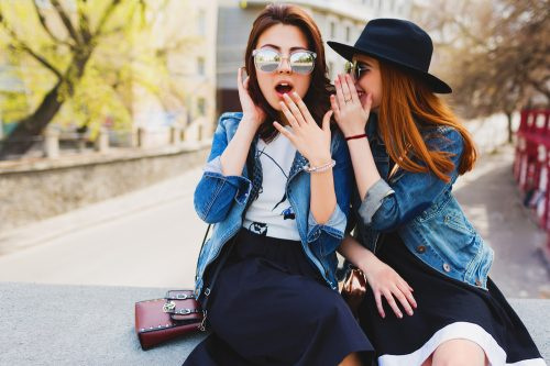   hai người phụ nữ đeo kính râm nói chuyện phiếm