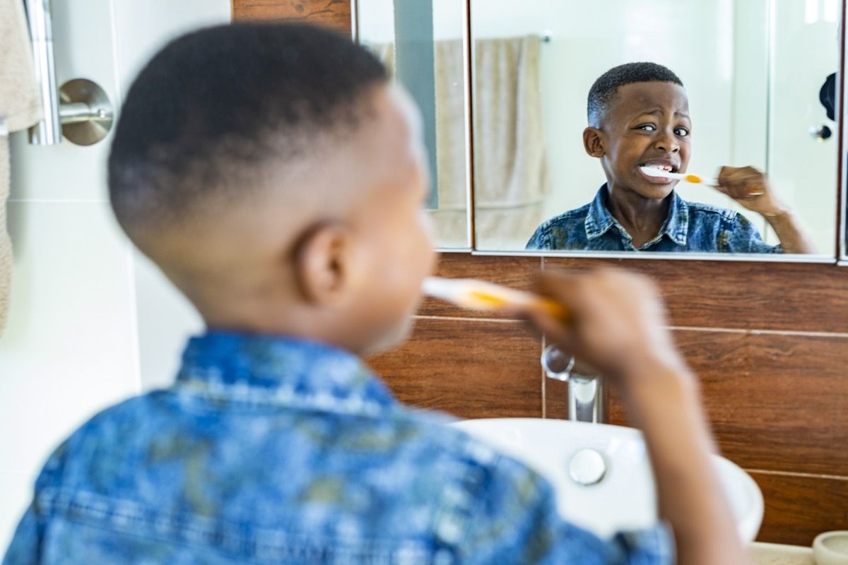 เด็กหนุ่มกำลังแปรงฟันด้วยแปรงสีฟัน