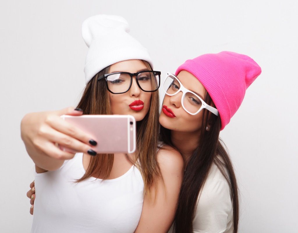 teini-ikäiset käyttävät typeriä laseja ja pipoina hattuja ja tekevät selfieä