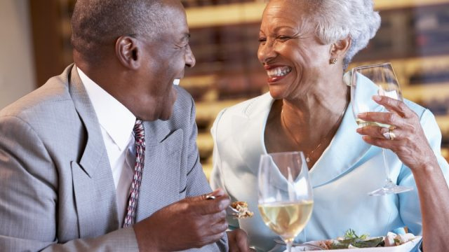   по-възрастна двойка се смее на вечеря