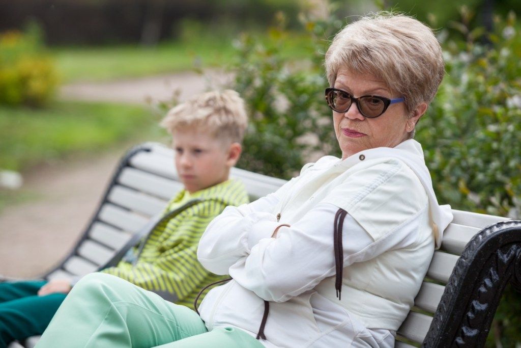 boze witte grootmoeder en kleinzoon op de bank