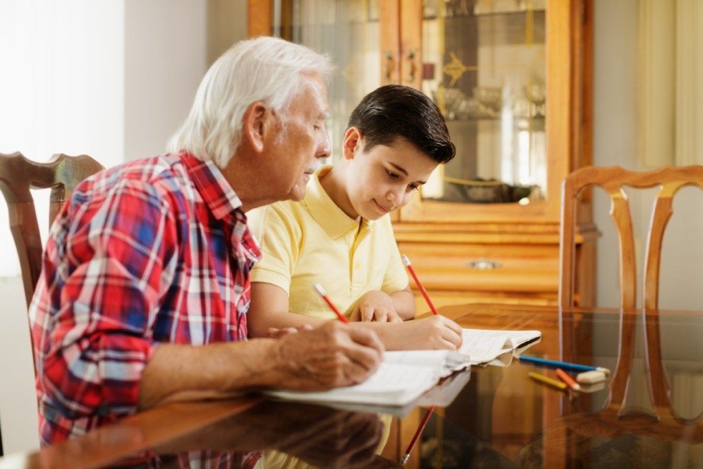 Opa und Enkel machen Hausaufgaben